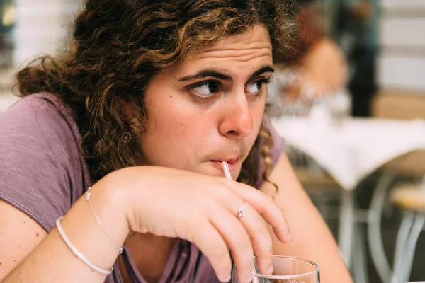 A young woman doubtful while drinking soda — Stock Photo, Image