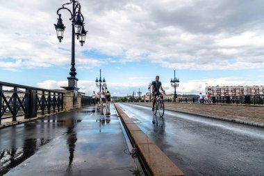 Bordeaux şehrinde Pont de Pierre köprüyü geçtikten bisikletçiler