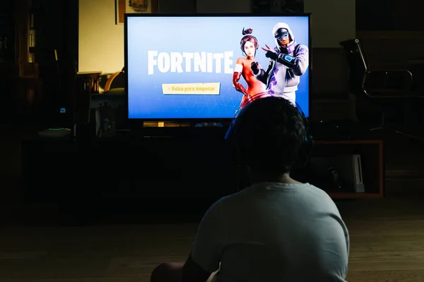 Tiener spelen Fortnite video game met PlayStation op TV — Stockfoto