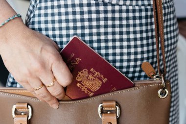 Şık kadının İspanyol pasaportunu çantadan çıkarırken çekilmiş fotoğrafı