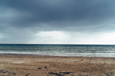 Kara bulutlar ve gelen yağmur fırtınası ile Plaj
