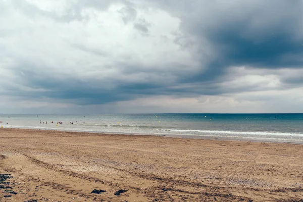 Пляж с тёмными облаками и приближающимся дождём — стоковое фото