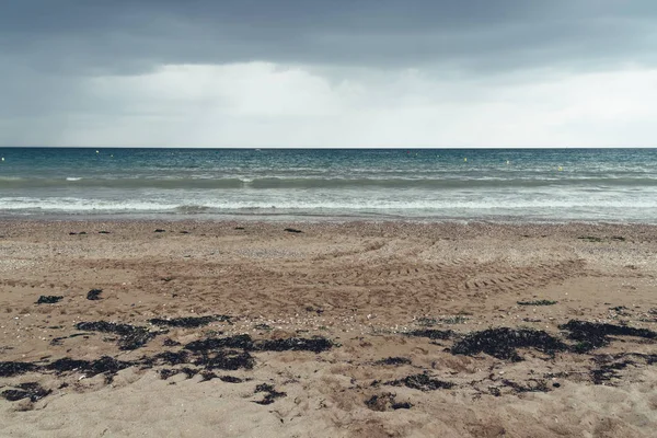 Пляж с тёмными облаками и приближающимся дождём — стоковое фото