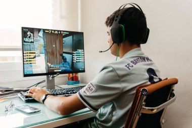 Teenager playing CSGO video game on PC clipart