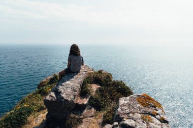 Brittany 'de deniz manzarasına bakan güzel bir kadın.