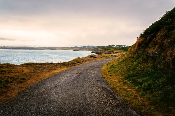 Bulutlu gökyüzüne karşı deniz tarafından yalnız yolun manzara görünümü — Stok fotoğraf