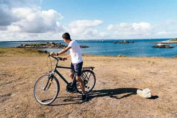 Attraktiver junger Mann fährt Fahrrad auf der Insel Batz — Stockfoto