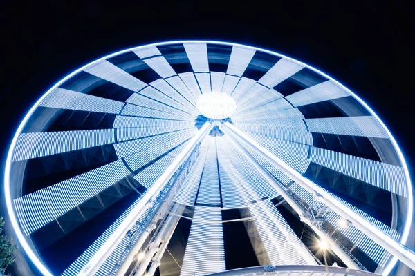 Крутящиеся колеса обозрения Структура неоновой экспозиции против черной ночи — стоковое фото