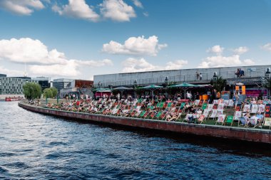 İnsanlar Berlin 'de Riverside' da açık barda eğleniyorlar.