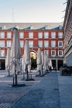 Closed touristic terraces in Plaza Mayor during coronavirus lockdown in Madrid clipart
