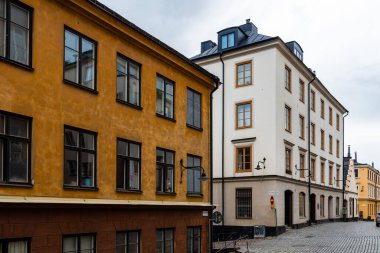 Stockholm 'de Sodermalm' de renkli evleri olan resimli kaldırımlı bir cadde.