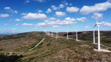 Rüzgar türbinleri Hill 'de elektrik üretiyor. Mavi gökyüzü beyaz bulutlu..
