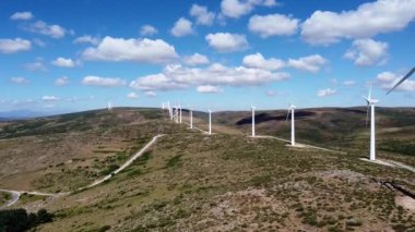 Rüzgar türbinleri Hill 'de elektrik üretiyor. Mavi gökyüzü beyaz bulutlu..