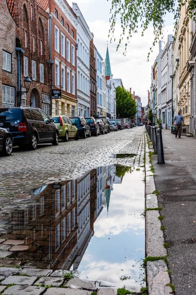 Gebäude spiegeln sich nach Regen in Pfütze in Lübecks Altstadt — Stockfoto