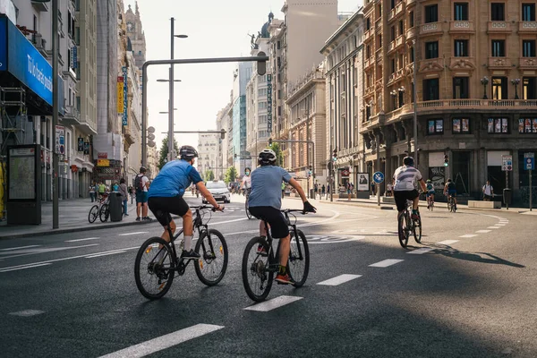 Ciclistas montando en una vacía avenida Gran Vía durante el bloqueo pandémico de Covid-19 en Madrid —  Fotos de Stock