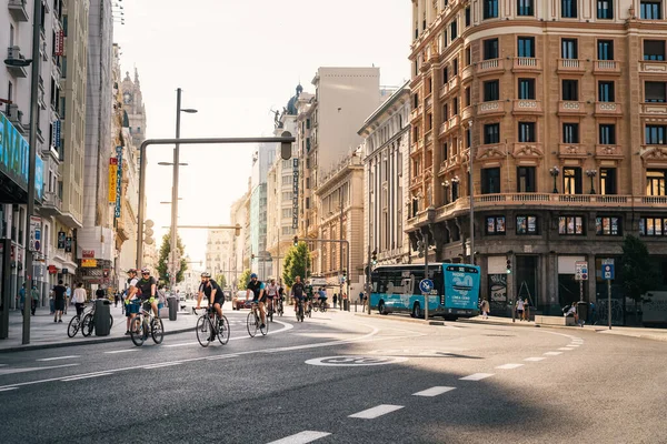 Madrid 'deki Covid-19 salgını sırasında boş bir Gran Via Bulvarı' nda bisiklet süren bisikletçiler. — Stok fotoğraf