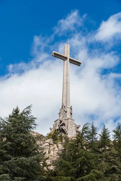 San Lorenzo de El Escorial, İspanya - 20 Temmuz 2025 El Escorial, Madrid 'deki Düşmüş Vadi' nin çarpıcı manzarası bulutlu bir gökyüzüne karşı yükselen haçın yer aldığı.