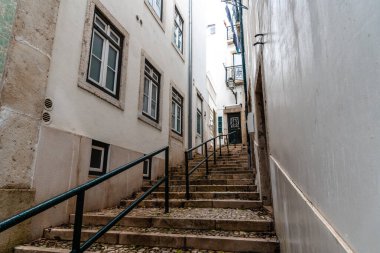 Portekiz 'in Lizbon' un tarihi Alfama semtinde, geleneksel binalarla çevrili dar bir merdiven yukarı doğru esiyor..
