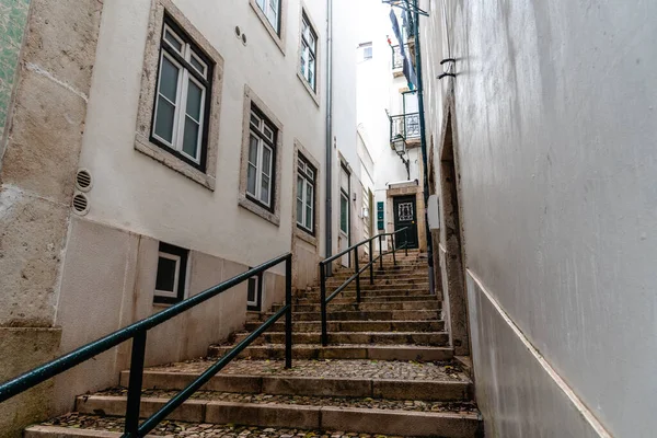 Portekiz 'in Lizbon' un tarihi Alfama semtinde, geleneksel binalarla çevrili dar bir merdiven yukarı doğru esiyor..