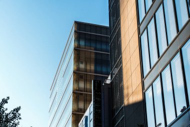 Tokyo, Japonya - 3 Ağustos 2024: Tokyo 'nun Ginza bölgesinde açık mavi gökyüzü altında cam cepheli modern binaların mimari görüntüleri.