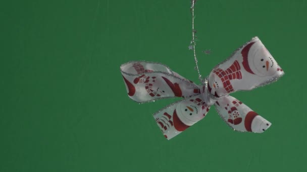 スノーマンデザインのシングルハンギングクリスマス弓はティンセルをオフにハンギング 緑の画面 ロックオフ — ストック動画