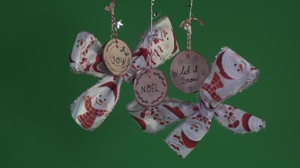 雪だるまのデザインと3つの木製の装飾とクリスマスの弓 緑の画面 ロックオフ — ストック動画