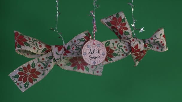 用Holly和Mistletoe设计和木制装饰挂圣诞之弓 绿色屏风 — 图库视频影像