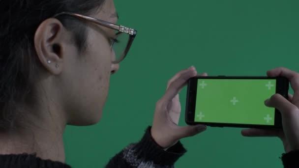 風景モードで緑の画面携帯電話を使用して女性の肩のビューの上 ロックオフ — ストック動画