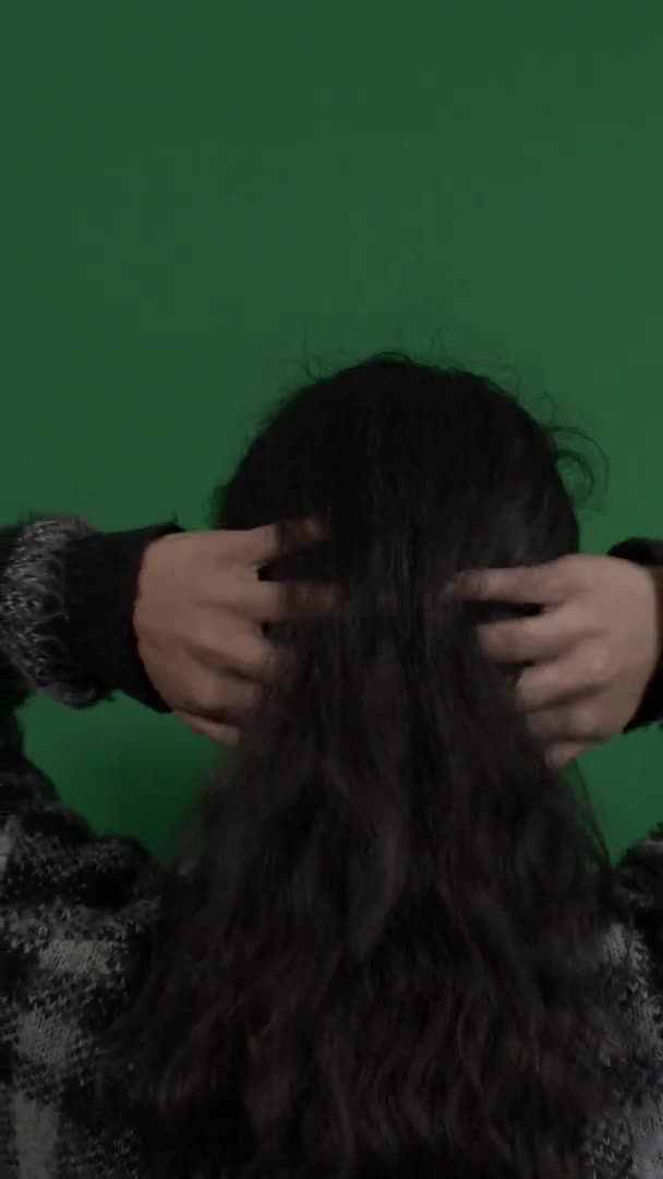 緑の画面の前で彼女の長いストレートの髪で遊んで女性のバックビュー 垂直ビデオ — ストック動画
