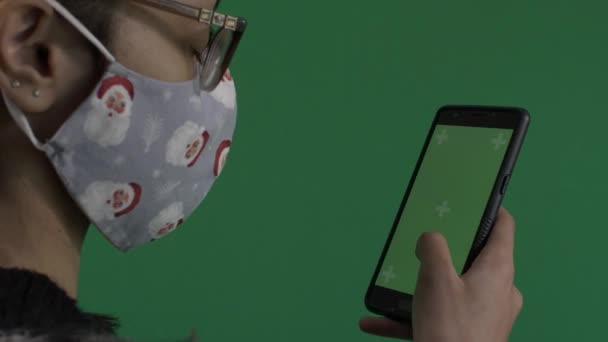 Молодая Женщина Маске Санта Клауса Держит Зеленый Экран Мобильного Телефона — стоковое видео