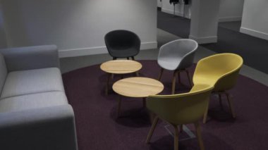 Tecrit süresince ofis zemininde sandalyeli, kanepeli ve küçük masalı boş toplantı alanı. Kilitli