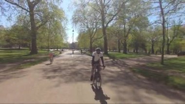 Güneşli bir günde Hyde Park, Londra 'daki tecrit sırasında Bisikletçiler Bisiklet Yolunda. Görüntüyü Takip Et