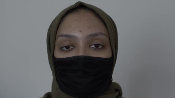 コットンブラックフェイスマスクを身に着けているヒジャブ女性 カメラを見てロックを解除 — ストック動画
