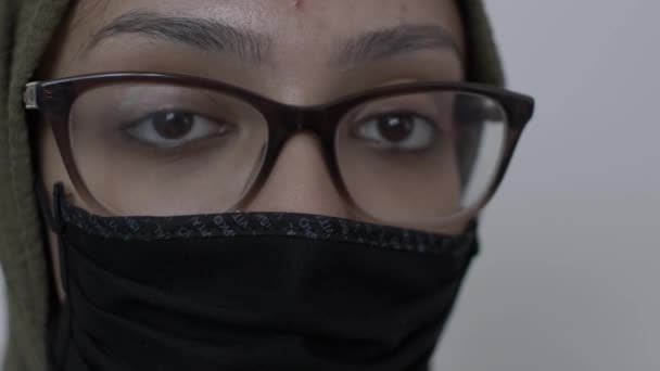 コットンブラックフェイスマスクを身に着けているメガネを持つヒジャブ女性 閉鎖しろ閉鎖しろ — ストック動画