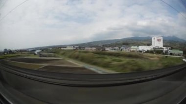 POV, kurşunlu tren penceresinden bakıyor ve Japonya 'yı hızla geçiyor. Geniş Açı