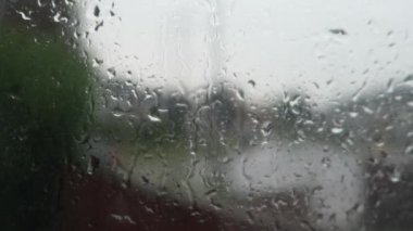 Caddenin dışındaki trafiğin geçmişi bulanıklaşmışken pencereye yağmur yağıyor. Kilitli, Kapalı