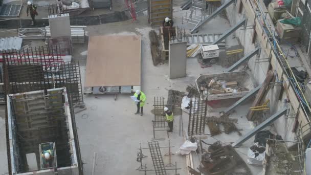 ハード ハットを被った建設労働者がウェストミンスターの9ミリバンク プレイスで動き回る 高角度 — ストック動画