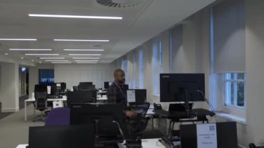 Yetişkin Birleşik Krallık Asyalı Erkek Tecrit Sürecinde Boş Ofiste Masaya Doğru Yürüyor. Kilitli 