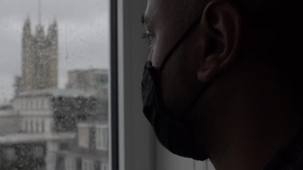 Άντρας Μάσκα Προσώπου Που Κοιτάει Έξω Από Βροχερό Παράθυρο Κλειδωμένο — Αρχείο Βίντεο