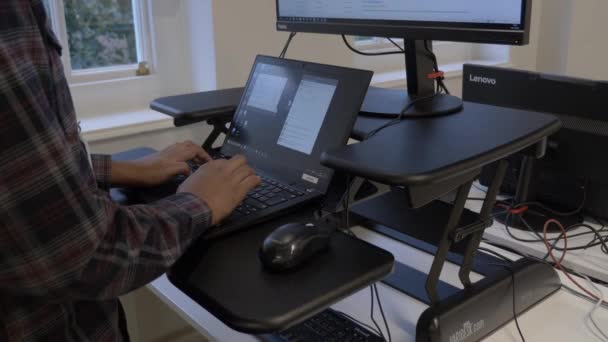 人間工学に基づいたスタンディングデスクでラップトップを使用する大人の男性 ロックオフ — ストック動画