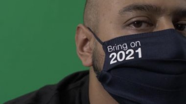 Yetişkin erkek giysisi 2021 'de kameraya bakarken yüzünü maskeledi. Yaklaş, Yeşil Ekran