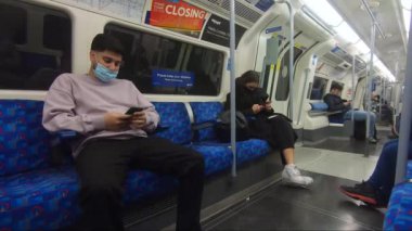 Londra Yeraltı Yolcuları Yüz maskeleri ve Sosyal Mesafe Giyiyorlar 