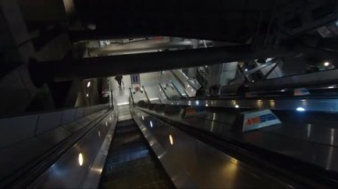 POV Londra 'daki Westminster İstasyonunda yürüyen merdivenden iniyor. Görüntüyü Takip Et