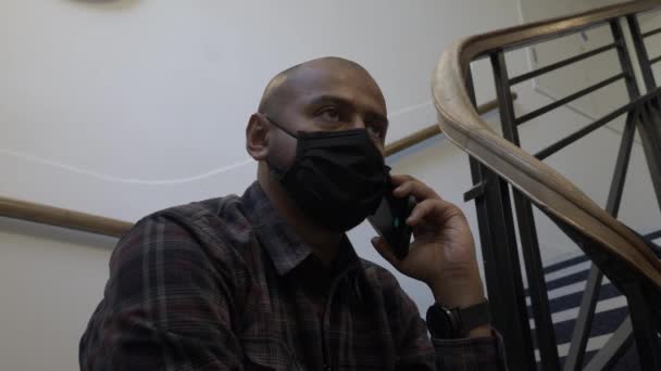 Ενηλίκων Μάσκα Προσώπου Χρησιμοποιώντας Κινητό Τηλέφωνο Κάθεται Κάτω Στις Σκάλες — Αρχείο Βίντεο
