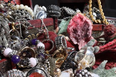 Yüzüklerle, kolyelerle, farklı boyutlarda ve renkte bileziklerle farklı sandıklarda çeşitli mücevherler.