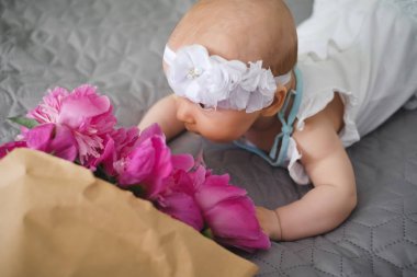 Şirin bebek yatak ve ilginç pembe çiçekler tarar