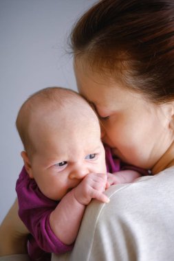 Sarılma ve öpüşme tatlı sevimli yeni doğmuş çocuğunu mutlu genç anne portresi