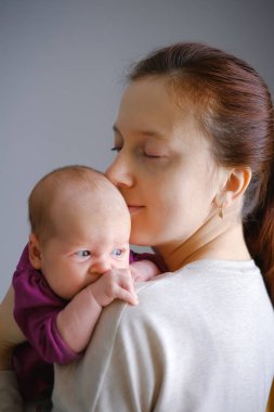 Genç Anne ve mutluluk hissediyorum duygu aşk. Öpüşme anne ve bebeği sarılma tatlı