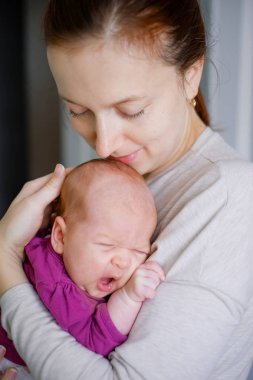 Sarılma ve öpüşme tatlı sevimli yeni doğmuş çocuğunu mutlu genç anne portresi