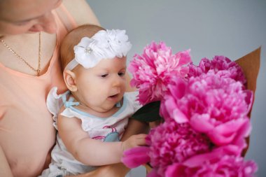 Mutlu genç onun yeni doğan çocuk anne ve çiçekler Buket gösterilen dünya keşfetmek yardım